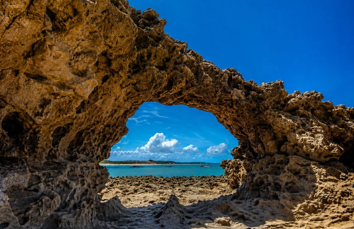 A natural rock arch is the main feature of Praia do Amor